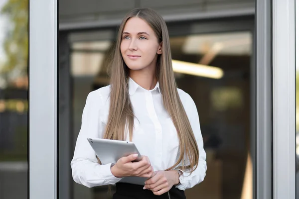 Mooi meisje maakt gebruik van Tablet PC op kantoor met glazen wanden. — Stockfoto