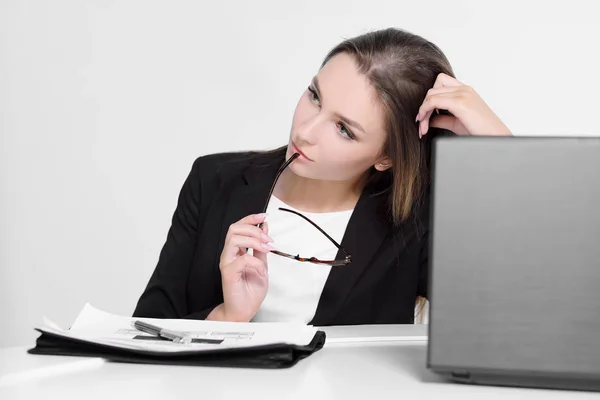 Zakenman meisje zitten aan de balie in kantoor en werken op de laptop op witte achtergrond. — Stockfoto