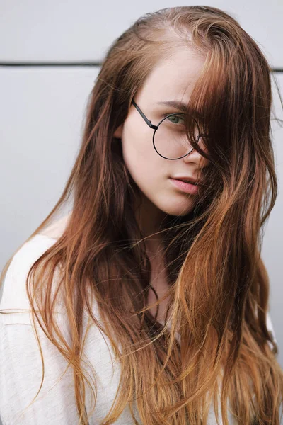 Street portrait of a red-haired girl wearing glasses. — Stock Photo, Image