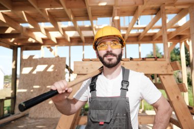 Adam bir ahşap çerçeve ev çatısında bir kurucusudur.