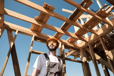 Adam bir ahşap çerçeve ev çatısında bir kurucusudur.