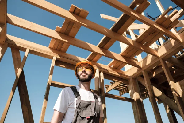 Adam bir ahşap çerçeve ev çatısında bir kurucusudur.