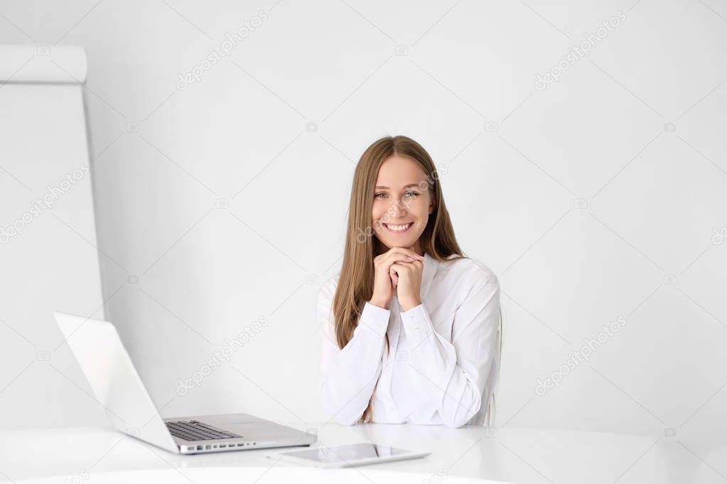 Young beautiful woman is working on a laptop in the office on a white background.