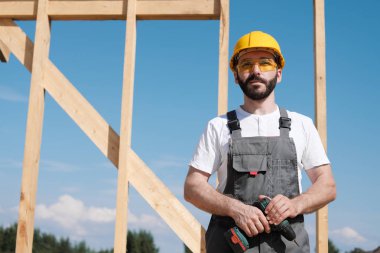 Adam bir ahşap çerçeve ev çatısında bir kurucusudur.