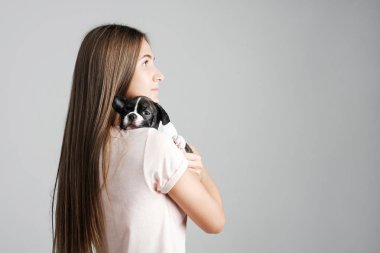 Genç güzel kız bir Fransız bulldog yavru sarılma