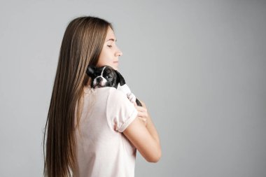 Genç güzel kız bir Fransız bulldog yavru sarılma