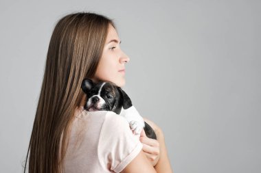 Genç güzel kız bir Fransız bulldog yavru sarılma