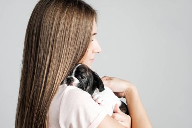 Genç güzel kız bir Fransız bulldog yavru sarılma