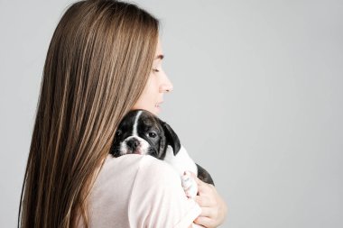 Genç güzel kız bir Fransız bulldog yavru sarılma