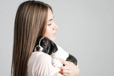 Genç güzel kız bir Fransız bulldog yavru sarılma