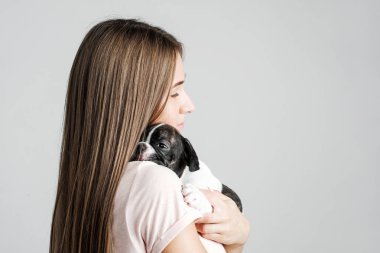 Genç güzel kız bir Fransız bulldog yavru sarılma