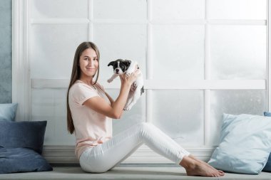 Genç güzel kız bir Fransız bulldog yavru sarılma