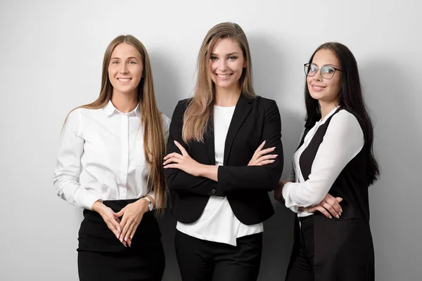 Tres hermosa joven sonriente mujer en ropa de negocios sobre un fondo blanco . — Foto de Stock