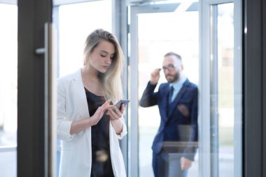 Bir erkek ve bir kadın ofis kapı girişinde konuşuyor, tanıdık.