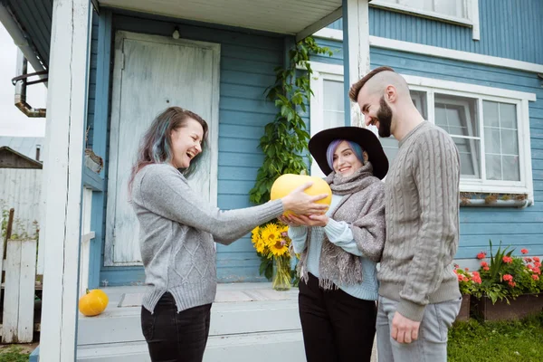Çiftlik köyü binasının arka planda üç kişi konuşmak ve gülmek.