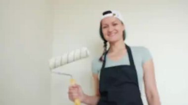 Rulo boya duvarlar. Genç bir kadın resim bej bir rulo ile evinde duvarlar. Yakın çekim.