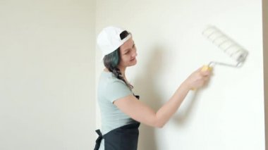 Rulo boya duvarlar. Genç bir kadın resim bej bir rulo ile evinde duvarlar. Yakın çekim.