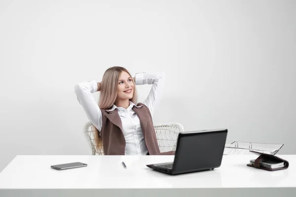 Kavkazská dívka sedící u stolu na počítači v kanceláři. Radost a úsměv. — Stock fotografie