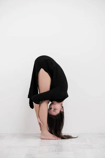 Sportig ung kvinna gör yoga praxis på vit bakgrund - begreppet hälsosamt liv och naturliga balans mellan kropp och mentala utveckling. — Stockfoto