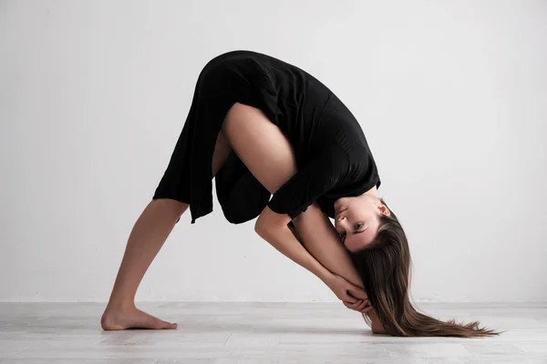 Jovem esportiva fazendo prática de ioga em fundo branco - conceito de vida saudável e equilíbrio natural entre corpo e desenvolvimento mental . — Fotografia de Stock