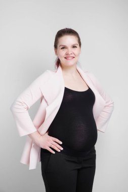 Genç hamile kadın iş casual beyaz arka plan üzerinde uygun.
