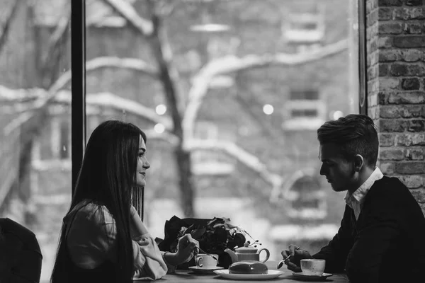 Mladý pár v lásce, muž a žena, sedí u stolu v kavárně. Den svatého Valentýna. — Stock fotografie
