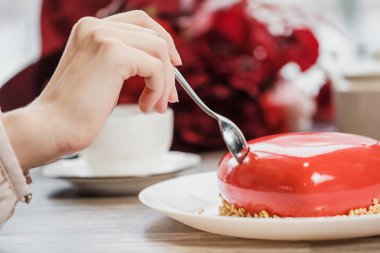 Kırmızı bir kalp şeklinde masaya pastadır. Kaşık, erkek ve kadın, iki elinle bir pasta streç.