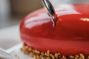 Kırmızı bir kalp şeklinde masaya pastadır. Kaşık, erkek ve kadın, iki elinle bir pasta streç.