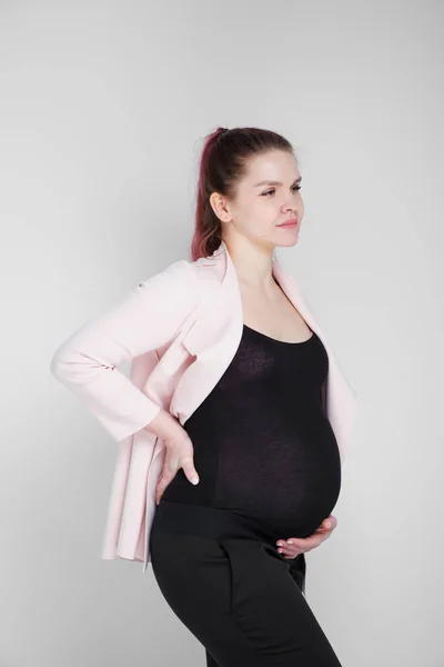 Chica embarazada aferrada a su espalda. Dolor, pesadez en la espalda . —  Fotos de Stock