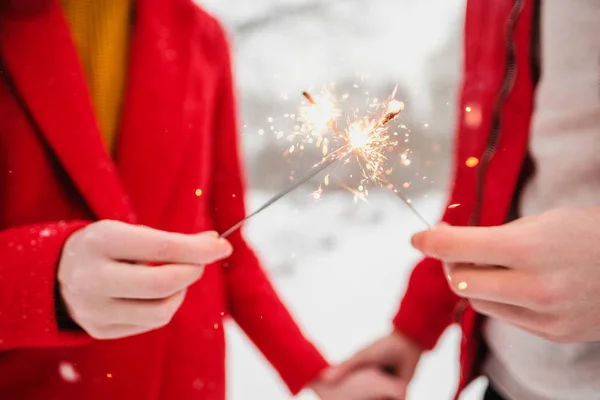 Espumantes e fogos de artifício nas mãos de um homem e uma mulher close-up . — Fotografia de Stock