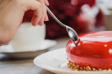 Kırmızı bir kalp şeklinde masaya pastadır. Kaşık, erkek ve kadın, iki elinle bir pasta streç.