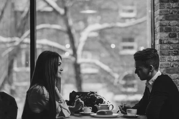 Giovane coppia innamorata, uomo e donna, sedersi a un tavolo in un caffè. Giorno di S. Valentino . — Foto Stock