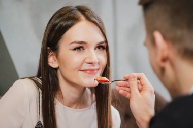 Aşık, bir erkek ve bir kadın, bir çift yemek kaşık ile bir kırmızı kalp şeklinde tatlı bir kafede.