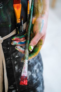 Kadın Sanatçılar bir fırça ve kırmızı boya ile ver. Siyah önlük, beyaz arka plan.