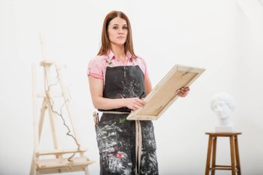 Genç kadın sanatçı bir kalem tuval üzerine çizer..