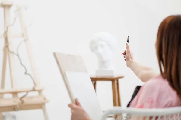 Młoda kobieta artysta rysuje ołówkiem na płótnie. — Zdjęcie stockowe