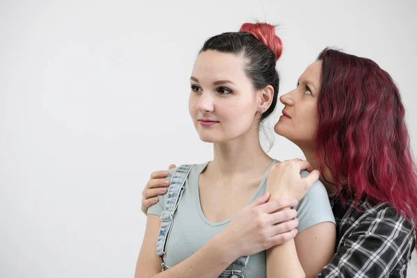 Two girls hug on a white background. Homosexual lesbian couple. Casual clothes. — Stock Photo, Image