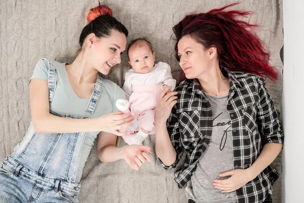 İki genç kadın, Eşcinsel, lezbiyen bir çift, bir battaniye var olan bir çocuğun yalan söylüyorsun. Eşcinsel evlilik, evlat edinme.