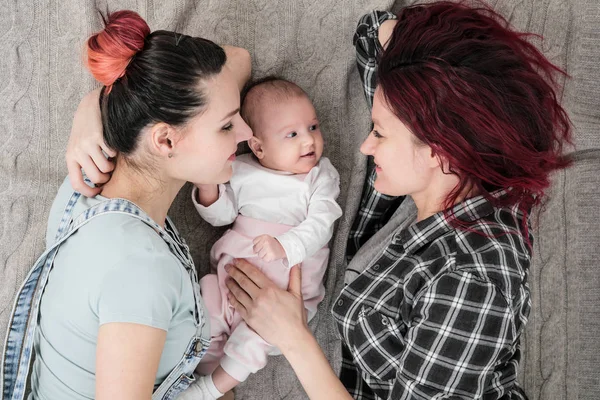 İki genç kadın, Eşcinsel, lezbiyen bir çift, bir battaniye var olan bir çocuğun yalan söylüyorsun. Eşcinsel evlilik, evlat edinme.