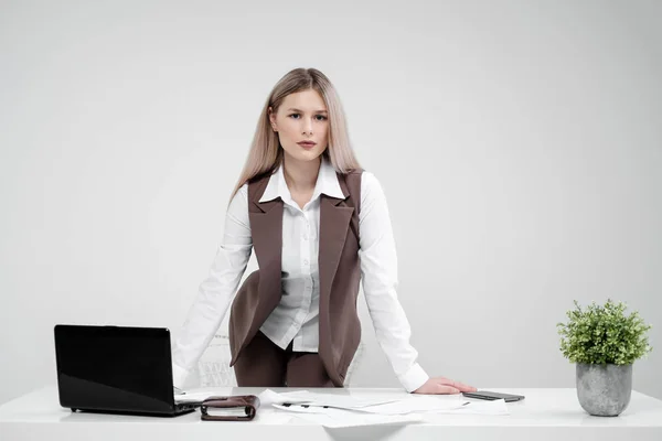 Blond dívka v obleku funguje na počítači v bílé světlé kanceláři. — Stock fotografie