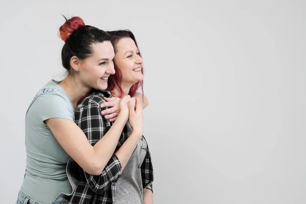 Two girls hug on a white background. Homosexual lesbian couple. Casual clothes. — Stock Photo, Image