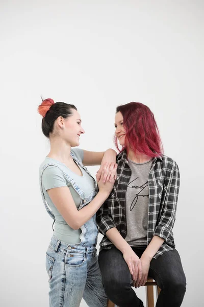 Two girls hug on a white background. Homosexual lesbian couple. Casual clothes. — Stock Photo, Image