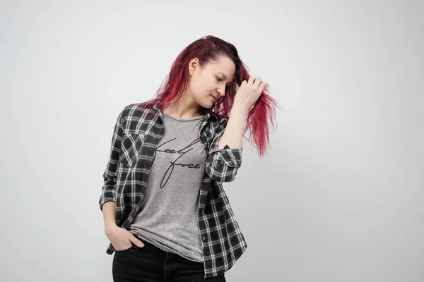 A menina em uma camisa cinza xadrez em um fundo branco com cabelo vermelho tingido . — Fotografia de Stock