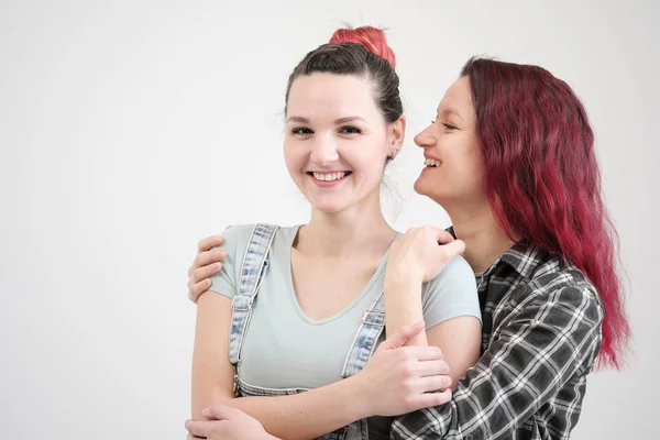 Two girls hug on a white background. Homosexual lesbian couple. Casual clothes. — Stock Photo, Image