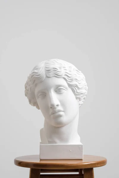 Çizmek için öğrenme için baş, antik heykel alçı. Beyaz bir arka plan bir taburede duran.