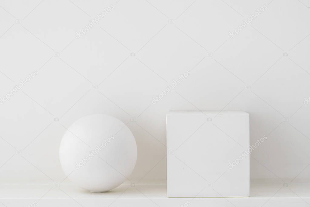 Plaster geometric shapes, sphere and cube on a white background.