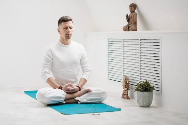 Morena masculina con barba en ropa blanca sobre fondo blanco con las manos dobladas en el pecho. Meditación y oración, yoga . — Foto de Stock