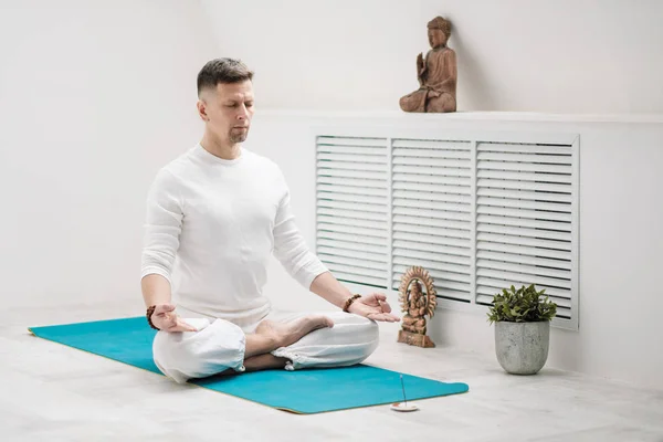 Morena masculina con barba en ropa blanca sobre fondo blanco con las manos dobladas en el pecho. Meditación y oración, yoga . — Foto de Stock