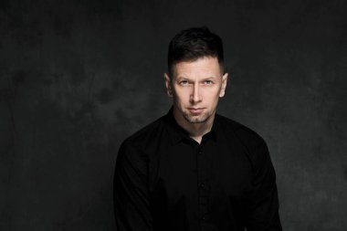 Bir karanlık sanatsal arka plan yakın çekim 40 yaşında yakışıklı bir adam portresi. Esmer, gri saçlı, Siyah sakallı ve siyah gömlek.