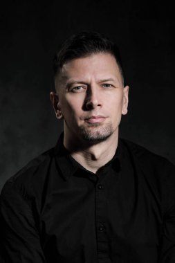 Bir karanlık sanatsal arka plan yakın çekim 40 yaşında yakışıklı bir adam portresi. Esmer, gri saçlı, Siyah sakallı ve siyah gömlek.